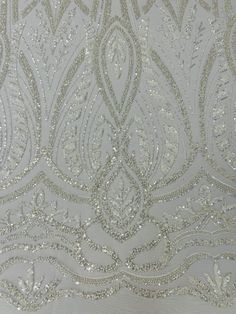 an embroidered fabric with silver sequins on it