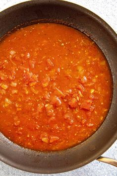 a pan filled with red sauce on top of a table