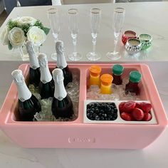 a pink tray filled with lots of bottles and glasses