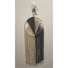 a macrame hanging on the wall next to a hair dryer and comb