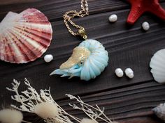 sea shells and seashells on a wooden table with starfish, pearls and other items