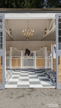 the inside of a horse stable with doors open