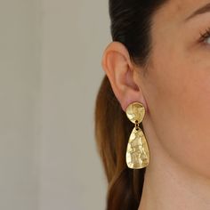 Organically shaped and textured, these dangly clip on earrings are expertly hammered and plated in warm antique gold metal making an intriguing and versatile addition to your jewelry box.Materials: 24 kt gold plated pewter.Measurements: 2"L x 1/2"W.Earring closure: Clip on.Earring weight: 0.28 oz. (medium weight) Gold-tone Metal Clip-on Earrings Tarnish Resistant, Gold-tone Tarnish Resistant Clip-on Earrings, Tarnish Resistant Gold-tone Clip-on Earrings, Gold-tone Tarnish-resistant Clip-on Earrings, Brass Drop Earrings With Clip-on, Brass Drop Earrings, Clip-on, Clip-on Brass Drop Earrings, Tarnish Resistant Gold-tone Brass Clip-on Earrings, Brass Dangle Clip-on Earrings