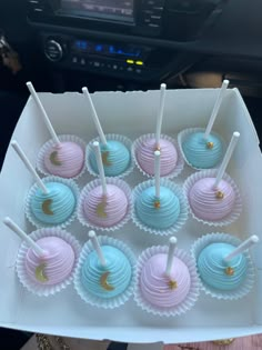 a box filled with blue and pink cupcakes on top of a white plate