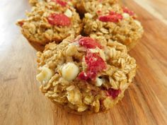 three granola muffins sitting on top of a wooden table