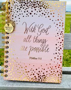 a pink and gold notebook with the words, with god all things are possible on it