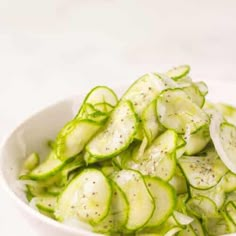 a white bowl filled with sliced cucumbers