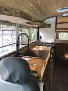 a kitchen area with sink, stove and counter in a trailer home that's built into the side of a truck