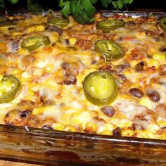 a casserole dish with cheese, jalapenos and other toppings