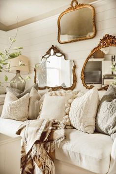 a living room filled with lots of furniture and mirrors