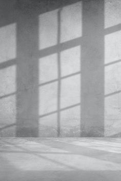 a black and white photo of a person sitting on a bench in an empty room