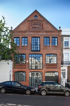 three cars parked in front of a brick building