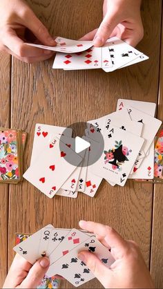 hands holding playing cards and placing them on top of each other to make a card game