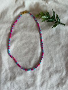 A cute seed beaded necklace with mixed berry colors! Colorful Beaded Necklaces With Tiny Round Beads, Colorful Tiny Beads Necklace, Trendy Turquoise Beaded Necklaces With Round Beads, Trendy Turquoise Round Beaded Necklace, Trendy Handmade Turquoise Beaded Necklaces, Trendy Beaded Necklace With Colorful Turquoise Beads, Pink Heishi Beads Necklace, Pink Heishi Beads Necklace With Tiny Beads, Pink Beaded Necklaces With Heart-shaped Beads