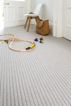 a child's toy train set laying on the floor in front of a chair