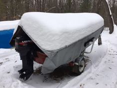 a boat covered in snow next to trees