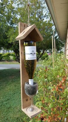 a wine bottle hanging from a bird feeder