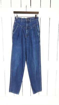 Vintage Ronica high waisted pleated tapered leg blue denim jeans/double side seam pleated jeans/waist 27" Measurements...taken flat      -across waist: 13.5"      -across hips: 17.5"      -inseam: 34"      -front rise: 13"      -marked size: vintage 10 (see measurements) Features... -super high 13" rise -the perfect medium blue wash -pleated hip with pockets -cool double seam down each leg -cool seam detail on front - tapered leg -100% cotton-no stretch -Ronica Condition:  -excellent vintage con Classic High Waist Medium Wash Pants, Classic Medium Wash High Waist Pants, High Waist Mom Fit Jeans With Belt Loops, High Waist Mom Jeans With Belt Loops, High Waist Tapered Dark Wash Jeans, Retro High Rise Jeans For Workwear, Dark Wash High Waist Mom Fit Bottoms, High Waist Dark Wash Mom Fit Bottoms, Retro High-waist Jeans For Workwear