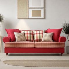 a living room with a red couch and two potted plants