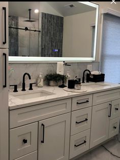 a bathroom with two sinks and a large mirror over it's counter top area