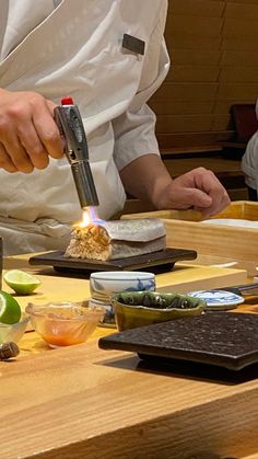 a chef is preparing food on a wooden cutting board with limes and other ingredients