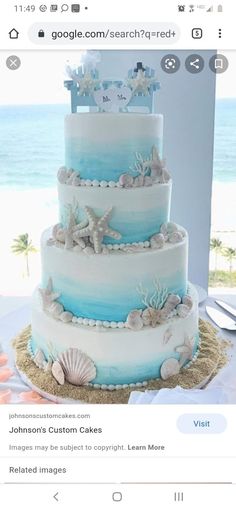 a blue and white wedding cake with seashells on it