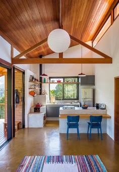 an open kitchen and dining area with wooden ceiling