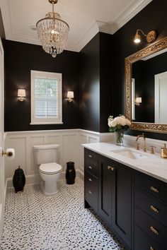 a white toilet sitting next to a bathroom sink under a mirror and a chandelier