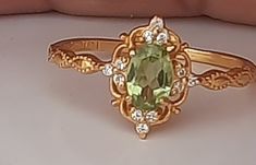 This Vintage Natural Peridot Ring is a stunning piece of jewelry that is perfect for any occasion. Made from solid 14K yellow gold, this ring is both durable and elegant. The peridot stone is the birthstone for August, making it an ideal gift for anyone born in that month. Whether you're looking for an engagement ring, a promise ring, or a birthday gift for her, this ring is sure to impress. The natural peridot stone adds a touch of color and sparkle to the design, making it a beautiful addition Gold Ring With Peridot, Vintage Peridot Engagement Rings, Gold Peridot Rings For Formal Occasions, Green Engagement Ring Vintage, Elegant Gold Rings With Peridot, Peridot Vintage Ring, Formal Peridot Diamond Ring In Yellow Gold, Formal Yellow Gold Peridot Birthstone Ring, Antique Peridot Rings