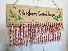 a wooden sign hanging from the side of a wall with candy canes attached to it