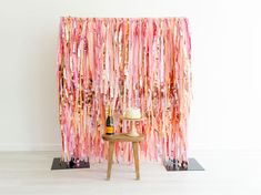 a table with a cake on top of it next to a pink and gold curtain