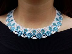 a woman wearing a blue and white beaded necklace