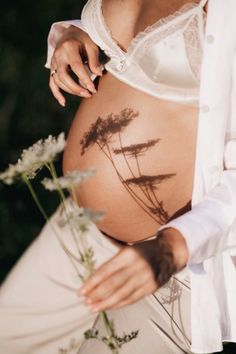 a pregnant woman holding flowers in her belly