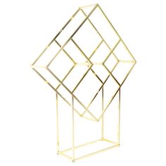 a gold geometric sculpture on a white background