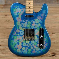 a blue guitar with flowers painted on it