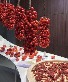 a pizza sitting on top of a table covered in toppings next to a bunch of cherry tomatoes