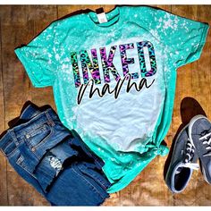 a green shirt that says inked mama on the front and back, next to some jeans