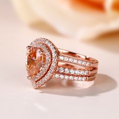 a close up view of a ring with an orange diamond in the center and two rows of diamonds around it