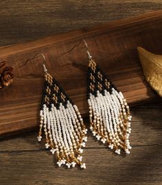 These handmade beaded earrings are a stunning accessory that seamlessly blends elegance with a touch of bohemian flair. Harmonious combination of black, yellow, and gold hues. These colors work together to create a striking contrast and an air of sophistication. The intricate craftsmanship and attention to detail make them a unique and eye-catching addition to any outfit. Approx 4 in.long Black Tassel Drop Earrings With Colorful Beads, Bohemian Black Tassel Earrings With Round Beads, Black Bohemian Tassel Earrings With Round Beads, Black Beaded Bohemian Tassel Earrings, Black Bohemian Beaded Earrings With Gold Beads, Bohemian Black Chandelier Earrings With Colorful Beads, Handmade Beaded Earrings, Handmade Earrings Beaded, Beaded Fringe