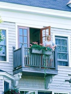 a woman standing on the balcony of a house