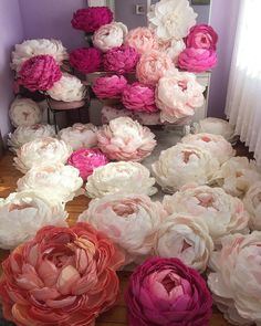 large pink and white flowers sitting on top of a wooden floor next to a mirror