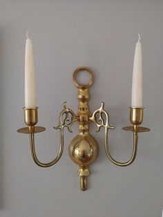 two candle holders are attached to the wall