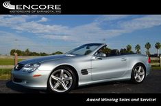 a silver mercedes slk convertible parked in a parking lot