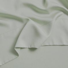 an unmade bed with white sheets and pillows