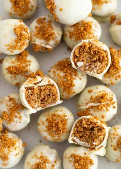 white chocolate covered desserts with orange sprinkles on top and crumbs all over them