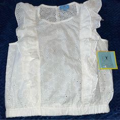 Adorable Ruffled Eyelet Sleeveless Top By Cece Brand-New With Tags In Ivory-Size Extra Small. Two Ruffles On Each Side On The Front And The Back-Elasticised Waist- One Button Closure - 100% Cotton Approximate Measurements:Iunderarm To Underarm 18”-Elastic Band Around The Bottom Across 15 Inches But Stretches-Length 19.5”-Machine, Washable, Cold (In The Description. The Only Colour Would Let Me Put Was White Or Cream, And It’s Ivory, Which Is Off White -It Doesn’t Look As White As The Pictures, B Cute Sleeveless Blouse With Ruffles, Cute Ruffled Tank Top For Spring, White Cotton Tops With Ruffled Straps, Summer Sleeveless Lace Top With Ruffles, Summer Cotton Lace Top With Ruffles, Spring Sleeveless Lace Top With Ruffles, White Tops With Ruffled Straps, White Feminine Tank Top With Ruffled Straps, Summer Short Sleeve Lace Top With Ruffles