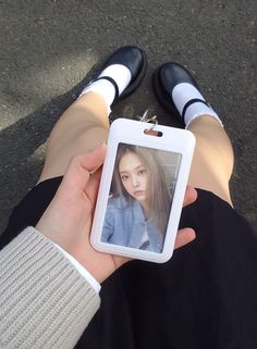 a person is holding up a cell phone with a picture attached to it's side