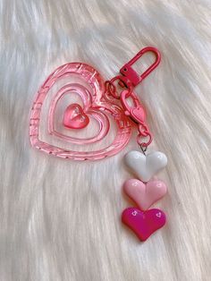 two heart shaped key chains on a white furnishing area with pink and white hearts attached to them