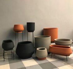 several different colored vases sitting next to each other on a checkered floor