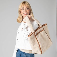 Add a touch of elegance to your daily look with the Toasty Tote. Crafted from luxurious cream-hued faux shearling, the bag features an eye-catching contrast with its faux suede binding and bottom panel. Secure your belongings with a zip pocket and snap button closure details. Carry your essentials in style with this must-have luxury piece. Features: Color: CreamMaterials: 100% PolyesterSize: 19" wide, 13" tall, 7" deepHandle: 10" Drop Chic Travel Shoulder Bag With Faux Fur Lining, Chic Beige Shoulder Bag With Faux Fur Lining, Everyday Shoulder Bag With Faux Fur Lining, Everyday Double Handle Shoulder Bag With Faux Fur Lining, Chic Everyday Shoulder Bag With Faux Fur Lining, Trendy Everyday Shoulder Bag With Faux Fur Lining, Trendy Shoulder Bag With Faux Fur Lining For Everyday, Everyday Tote Shoulder Bag With Faux Fur Lining, Everyday Beige Bags With Plush Lining